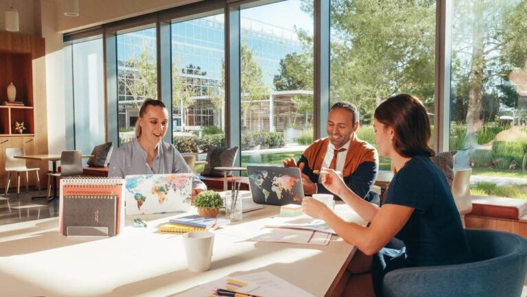 A lean team of three working together in a bright, open office.