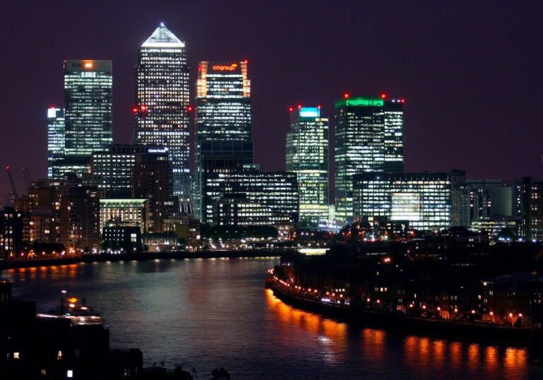 Highest Paying Careers in the UK are often found in Canary Wharf. The photo is at night, showing the Isle of Dogs and Canary Wharf lit up along the river Thames.
